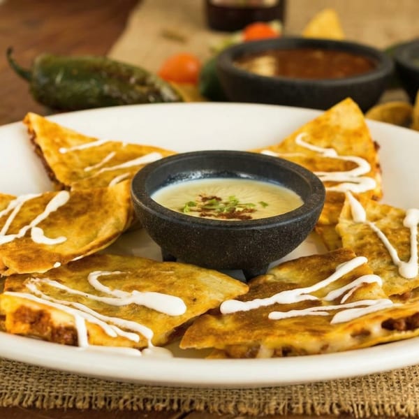 El Cerro Grande's quesadillas with sour cream drizzle, served with a side of queso dip.